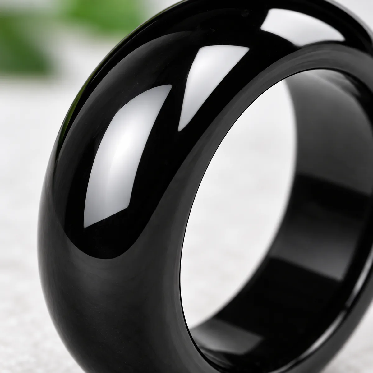 Bague jade noir, néphrite sombre polie, gros plan sur le grain et la translucidite de la pierre