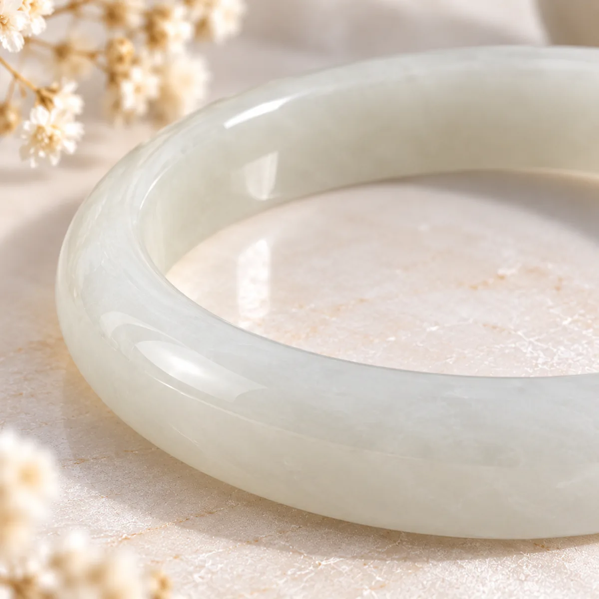 Jonc en néphrite blanche, bracelet fermé, gros plan sur le grain et la translucidite de la pierre