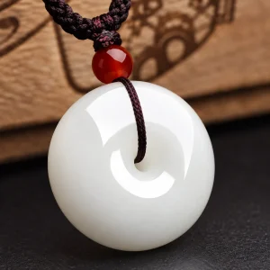 Pendentif jade blanc, disque percé de néphrite