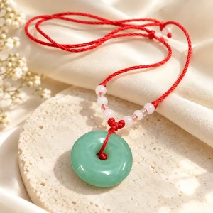 Collier cordon rouge et disque de jade vert
