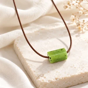 Pendentif tube de jade sur cordon brun